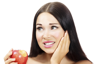 Smiling senior woman with new dental implants sitting in the dental office and looking at the mirror